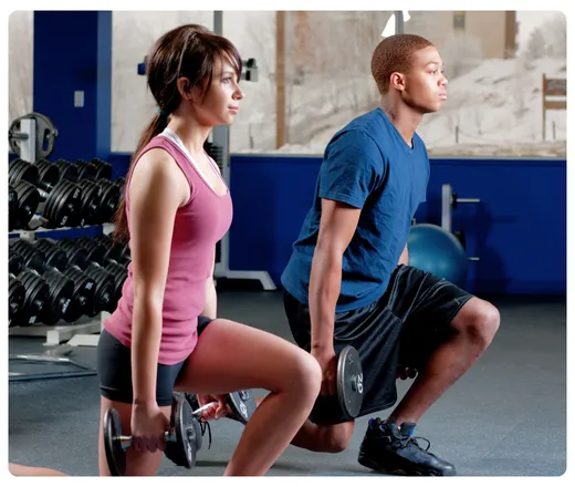 two teens doing weighted squats.