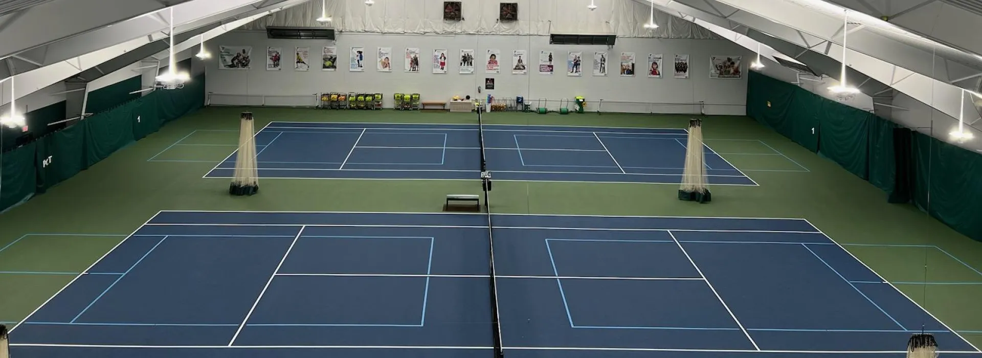A bird's eye view shot of the inside of the tennis &amp; pickleball center, looking down at the courts.